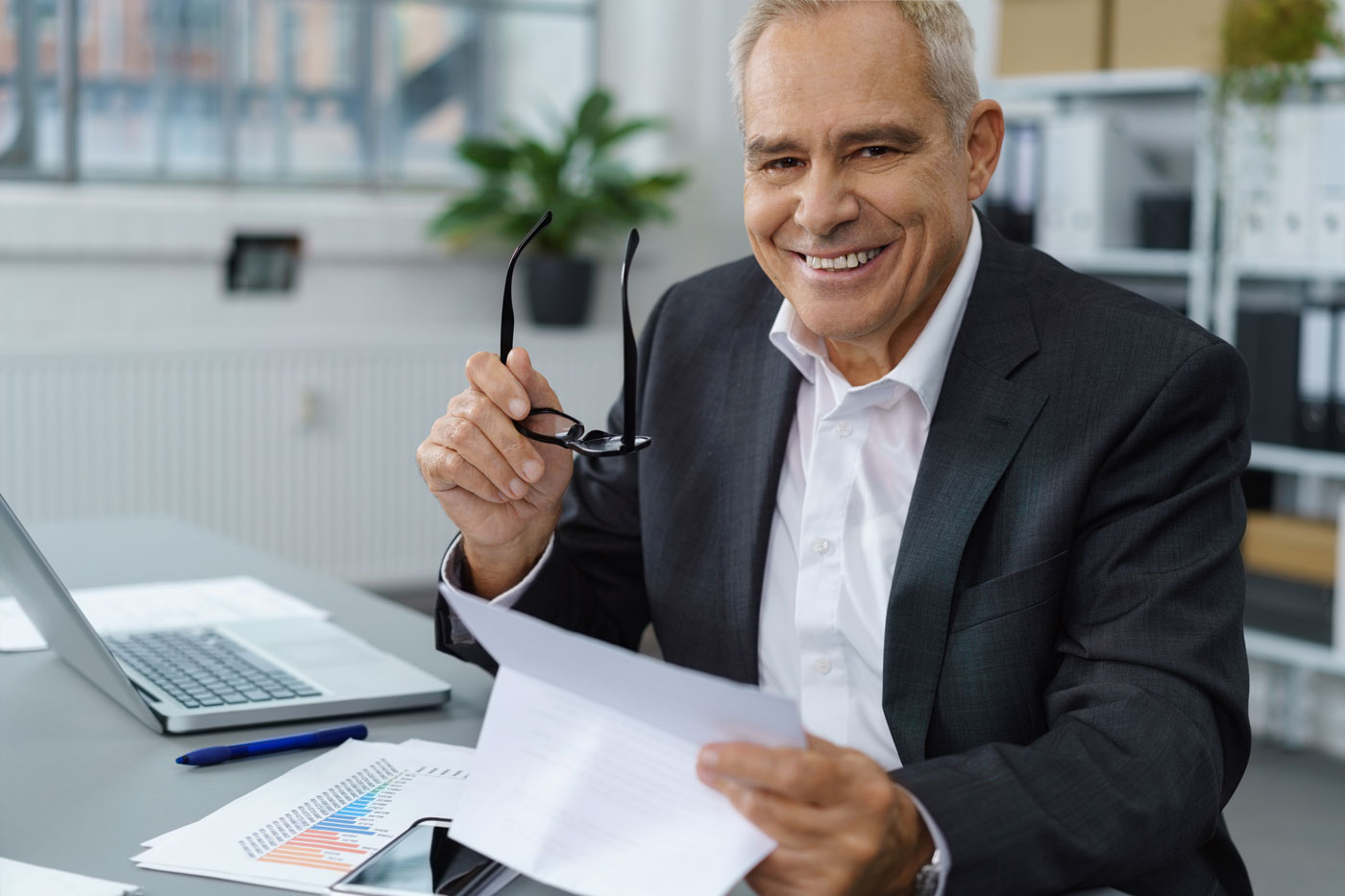 Men in office smiling with glasses in hands